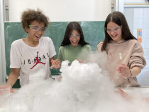 Drei Schüler experimentieren mit großer Freude im Chemieunterricht an der RS Stadtmitte